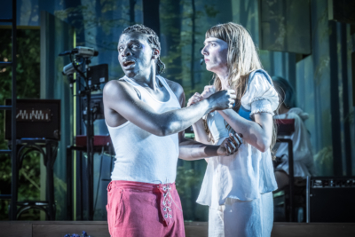 Demetrius (Terique Jarrett) tries to untangle himself from Helena (played by Mary Malone). This is a production of “A Midsummer Night’s Dream” performed at Regent’s Park Open Air Theatre (London) in 2026. Photography by Marc Brenner.