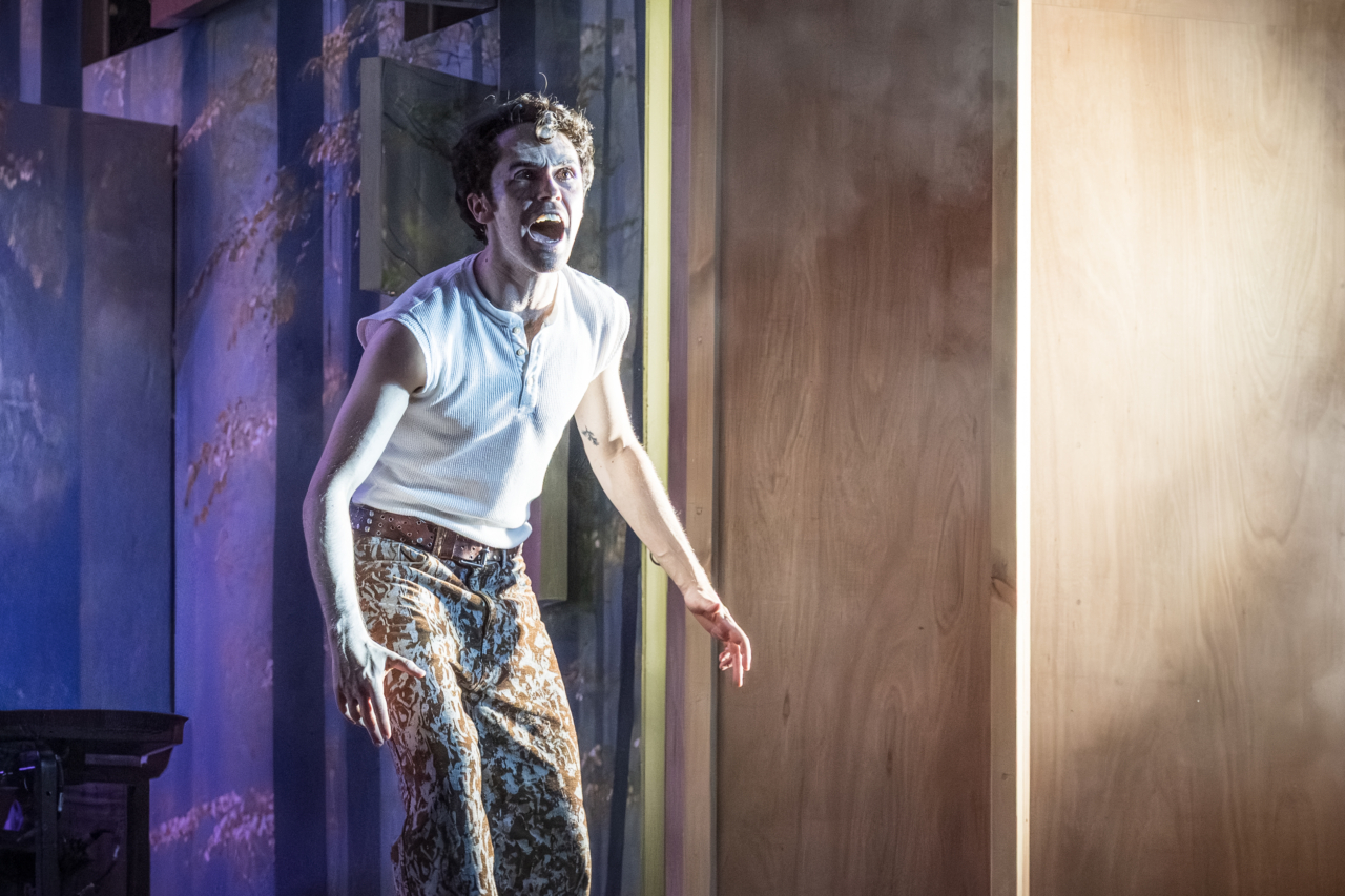 Lysander (played by Misia Butler) yells, his face twisted in frustration. This is a production of “A Midsummer Night’s Dream” performed at Regent’s Park Open Air Theatre (London) in 2026. Photography by Marc Brenner.